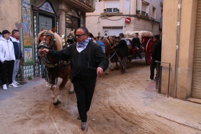 Un home guia un carro durant el recorregut dels Tres Tombs de Valls