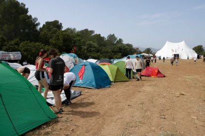 Un grupo de personas prepara una tienda en la zona de acampada de Revoltes de la Terra en Mont-roig del Camp