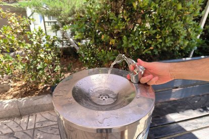 Una font d'aigua, a la plaça de Prim de Reus, sota una carpa d'Aigües de Reus.