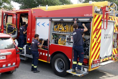 Bomberos cargan y preparan material en uno de los camiones que forman parte del convoy que viaja hacia el oeste de la península.