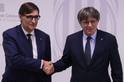 El presidente Salvador Illa y el expresidente Carles Puigdemont encajan las manos antes de reunirse este martes en Bruselas