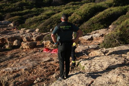 Un agent de la Guàrdia Civil i un bomber davant del cos sense vida de l'home.