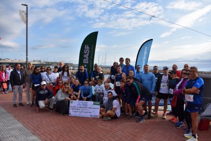 Imagen de los participantes de la carrera con el cheque solidario