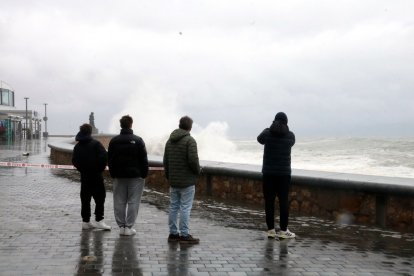 Curiosos fent fotos de les onades a l'Escala