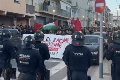 Concentració de veïns i assistents contraris a la marxa ultradretana, encapsulats pels Mossos.