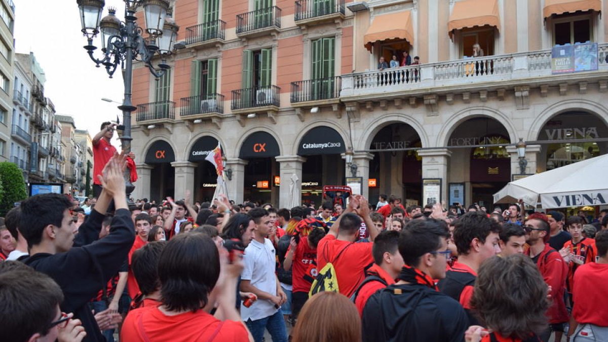 Después de la primera celebración en el campo del CF Reus Deportiu, los aficionados se han dirigido a la plaza de Prim para seguir festejando el ascenso directo a Segunda División A.