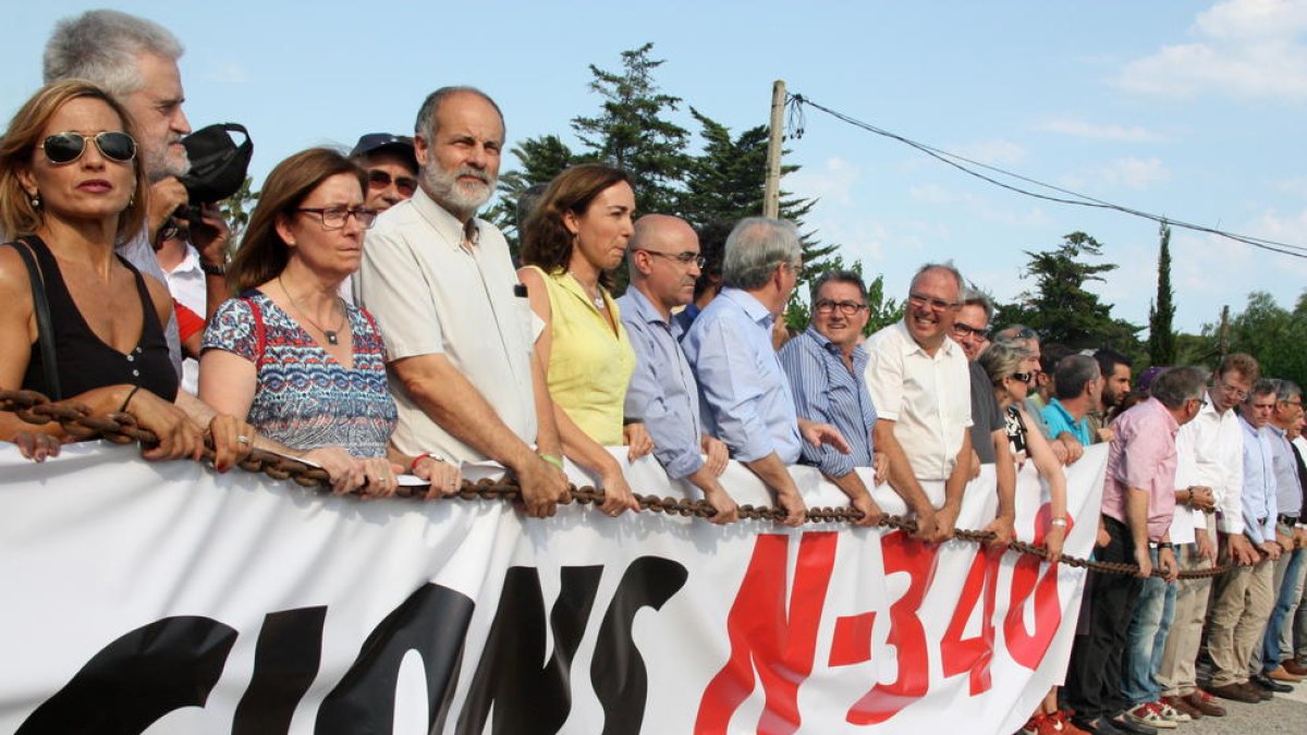 Pla general de diversos alcaldes rere la pancarta i la cadena que reivindica 