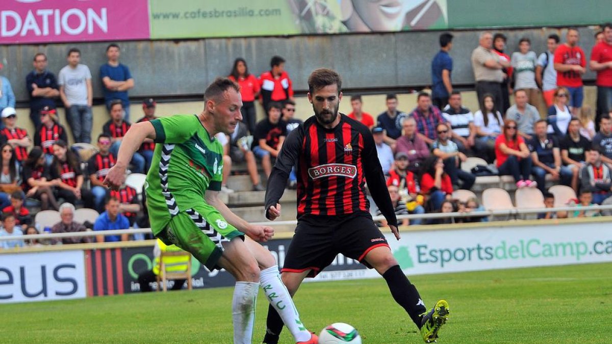 Migue, en un partido contra el Reus, luchando por una pelota con Alberto Benito