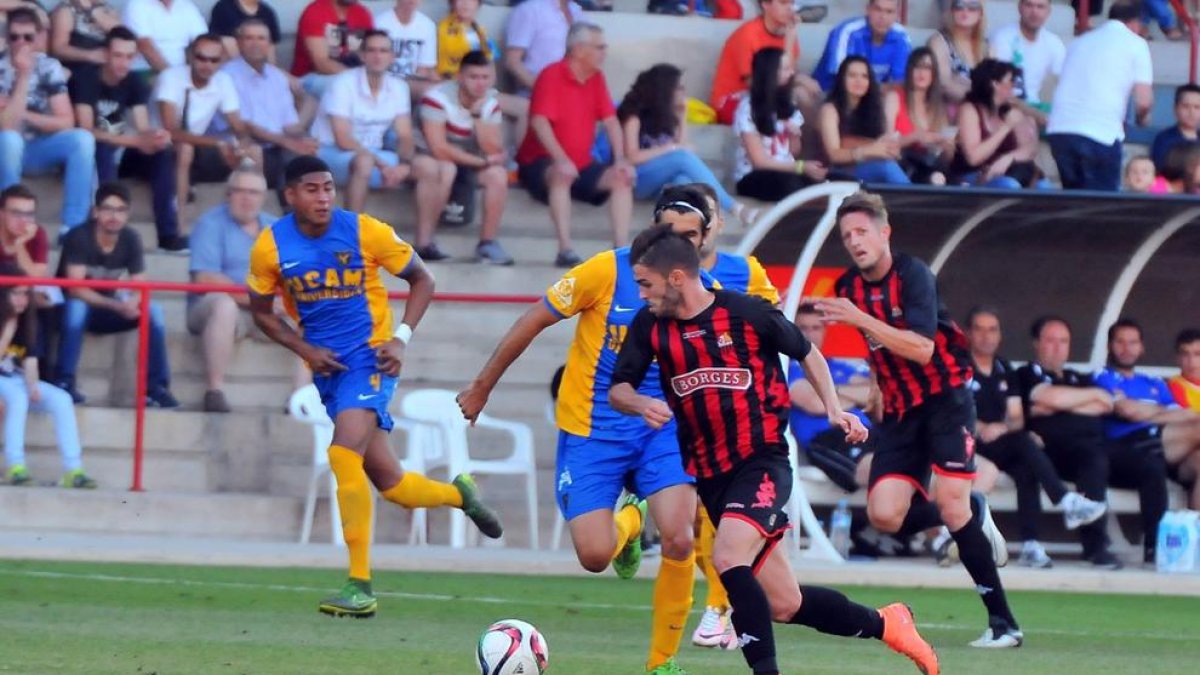 Fran Carbia avanza con la pelota bajo la mirada de Edgar Hernández.