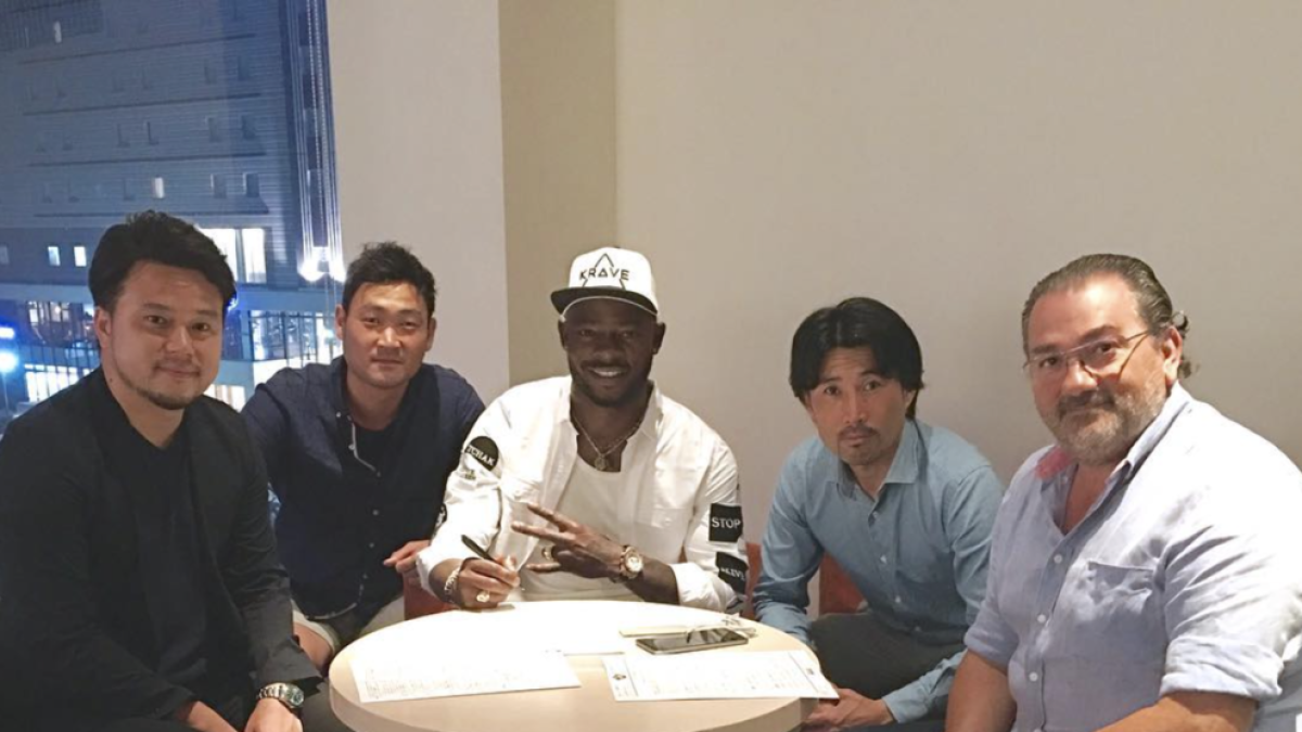 Imatge del jugador camerunès signant el contracte a Tokushima.