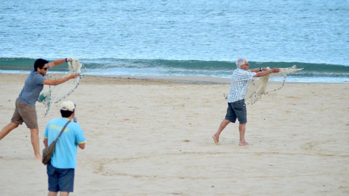 Un pescador 'de toda la vida' y su hijo, haciendo una demostración de artes de pesca tradicionales.