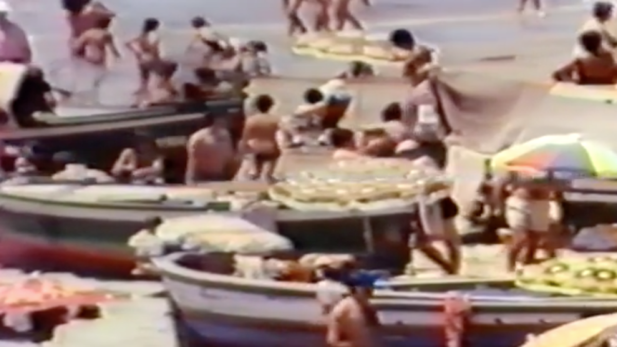 Una imagen del vídeo, donde se pueden ver personas en la playa en las barcas sobre la arena.