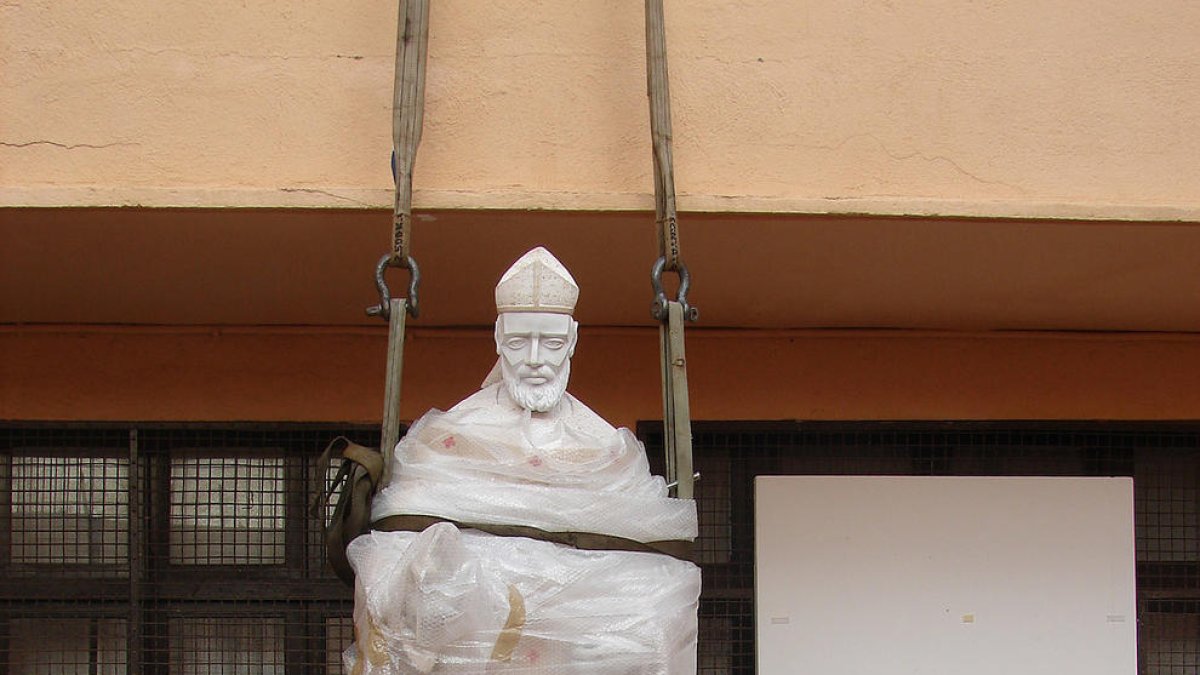 Gallart i un ajudant, col·locant l'escultura al pati de la casa.