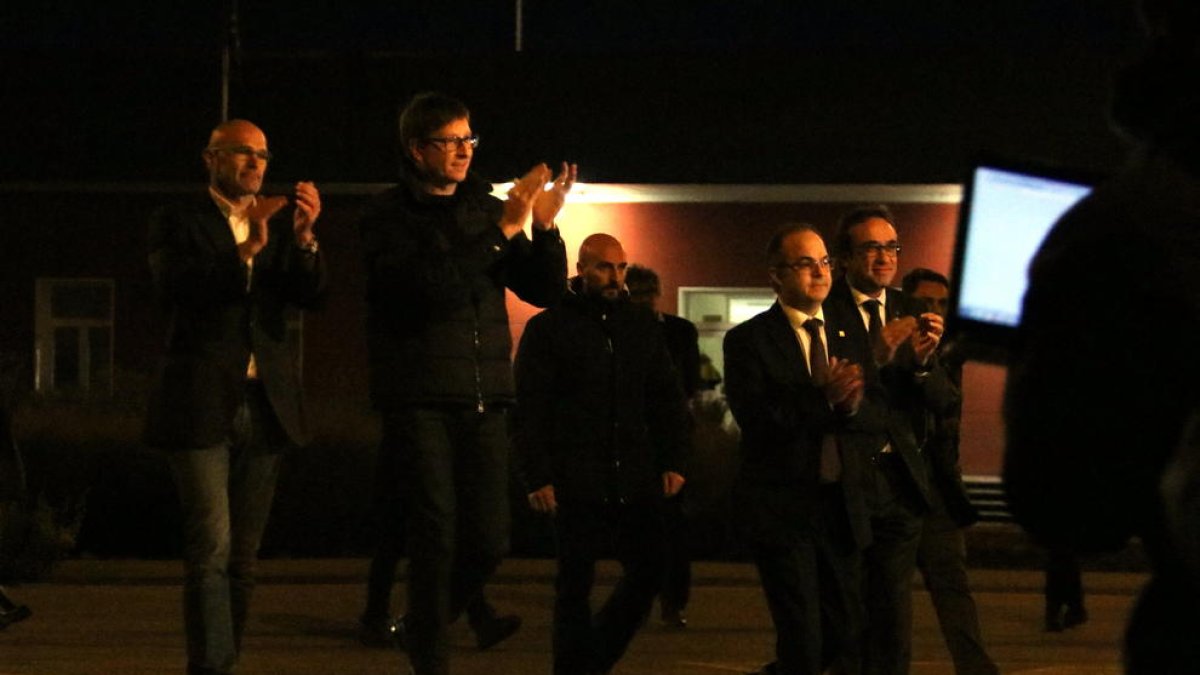 Romero, Mundó, Rull y Turull con las manos arriba|en el aire agradeciendo el apoyo|soporte en el momento salir de la prisión d'Estremera.