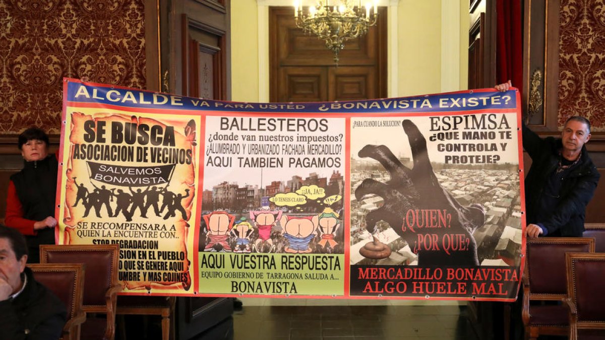 El propietario del bar Los Pilares, protestando con una pancarta al pleno de este jueves.