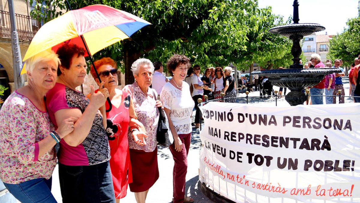 Un grup de dones de Batea davant una pancarta crítica amb la proposta de l'alcalde de marxar a l'Aragó.