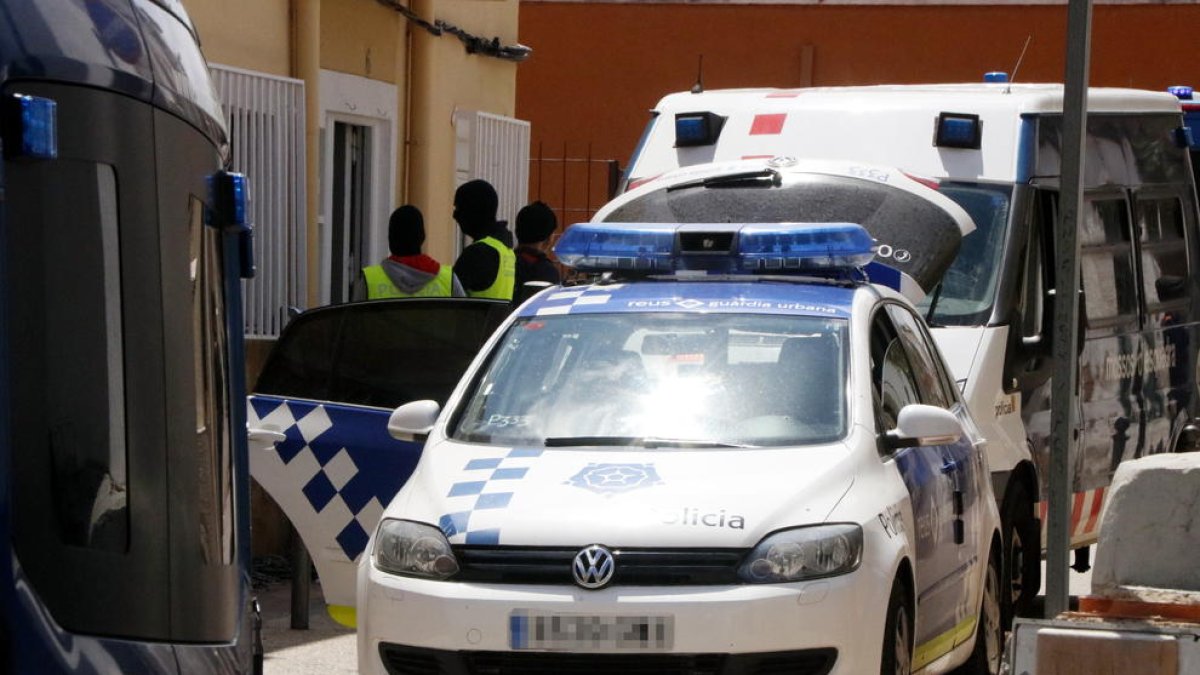 Els Mossos i la Guàrdia Urbana de Reus davant del domicili on s'ha dut a terme un operatiu antidroga, amb un vehicle policial en primer terme.