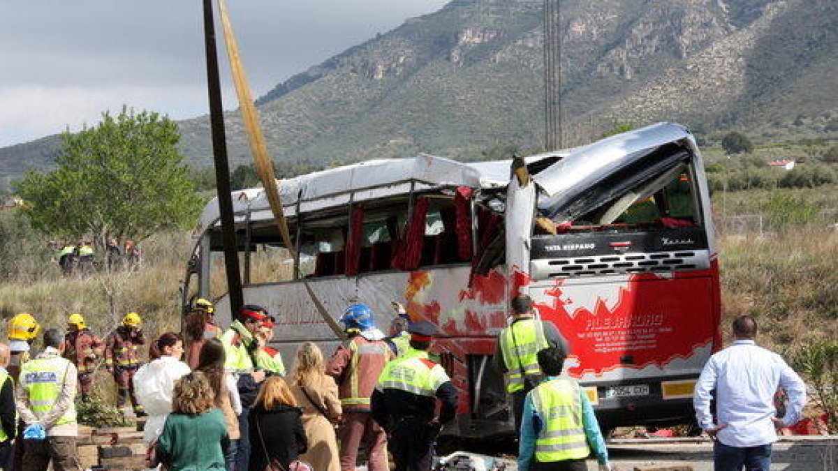 Efectius dels Bombers i Mossos observant l'autobús accidentat un cop la grua l'ha aixecat