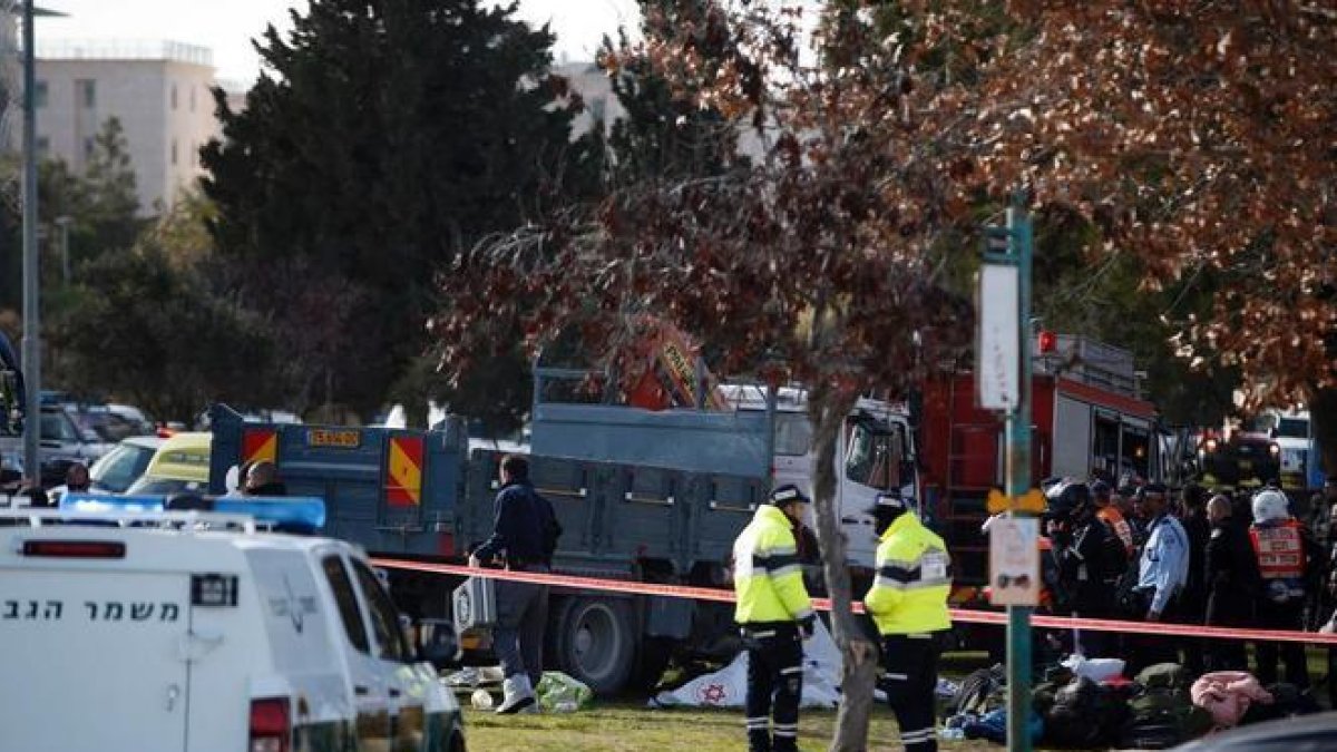 Las fuerzas de seguridad y los servicios médicos trabajan al lado del camión.