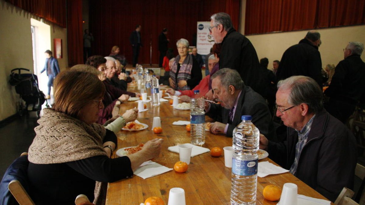 Una mesa del DiNadal con varias personas comiendo arroz blanco con tomate.