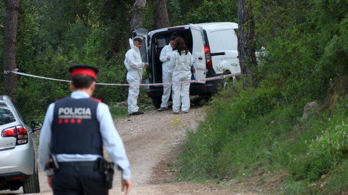 Pla general de la policia científica equipant-se per accedir al lloc on s'ha trobat un cos calcinat al costat del Pantà de Foix. En primer pla, un agent dels Mossos d'Esquadra. Imatge del 5 de maig de 2017