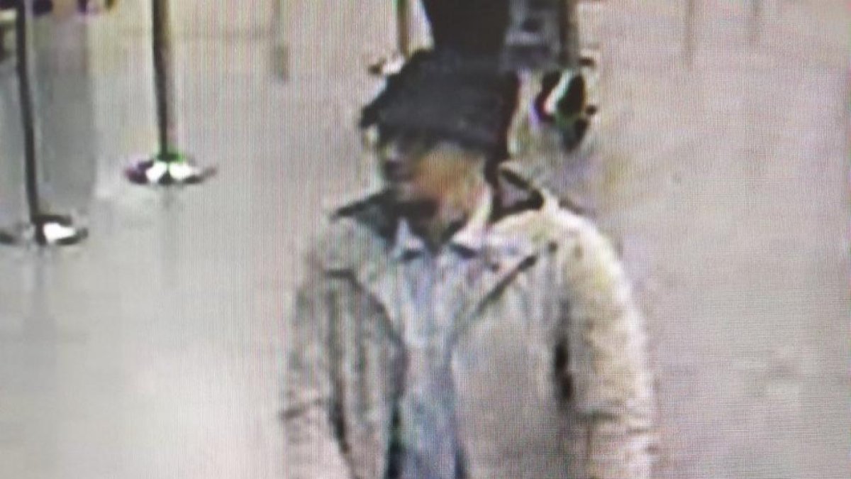 Imatge difosa per la policia belga del sospitós dels atemptats a l'aeroport de Brussel·les, on es veu un home amb jaqueta blanca i barret empenyent un portaequipatges.