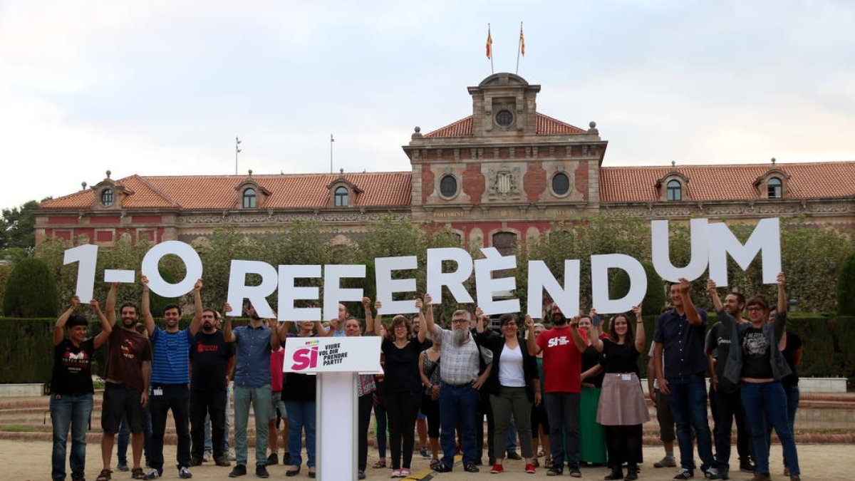 Miembros de la CUP levantando las letras de Referéndum ante el Parlamento.