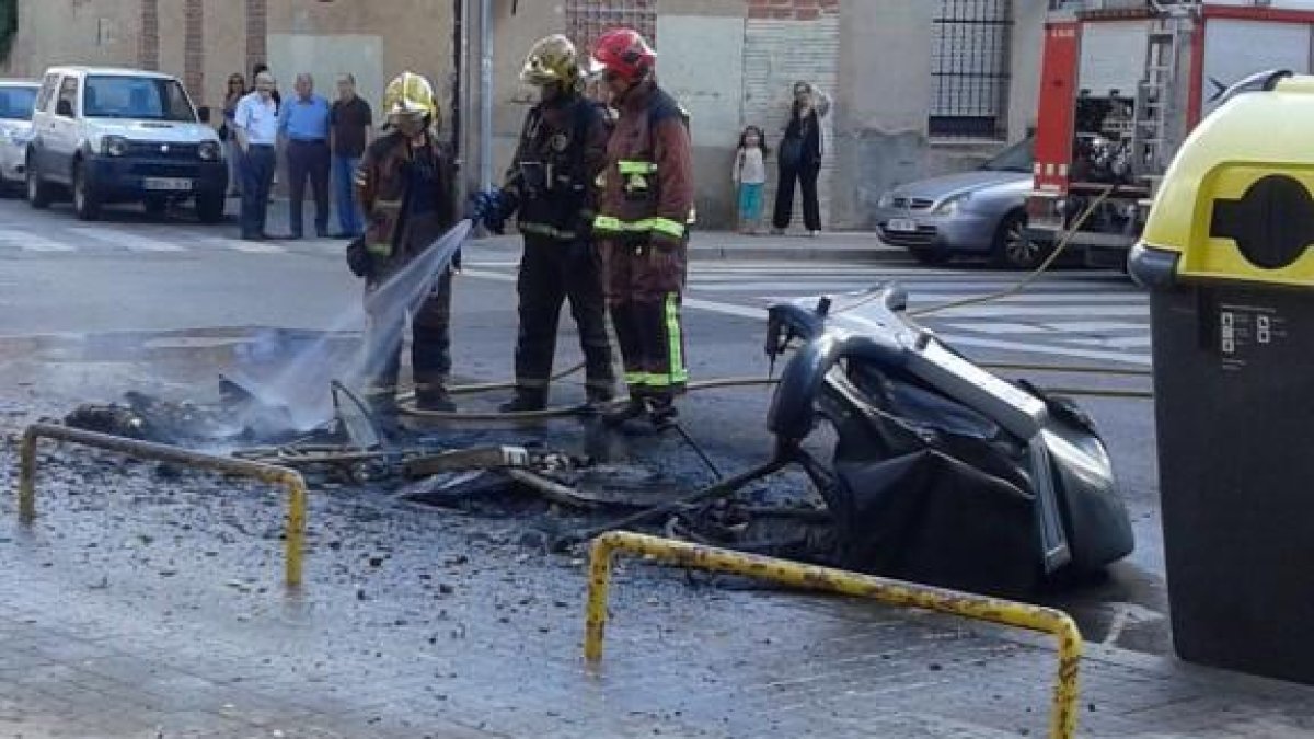 Imagen de archihuevo de los bomberos apagando un contenedor incendiado