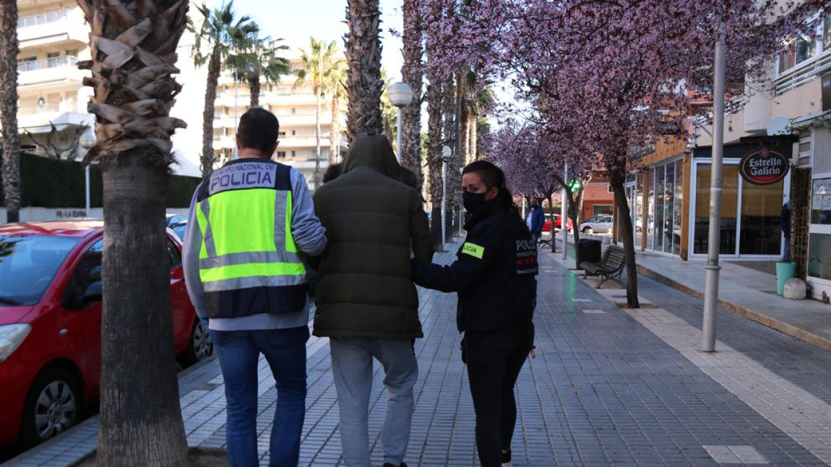 Agentes de los Mossos d'Esquadra y de la Policía Nacional con el detenido en la salida del segundo registro realizado en Salou.