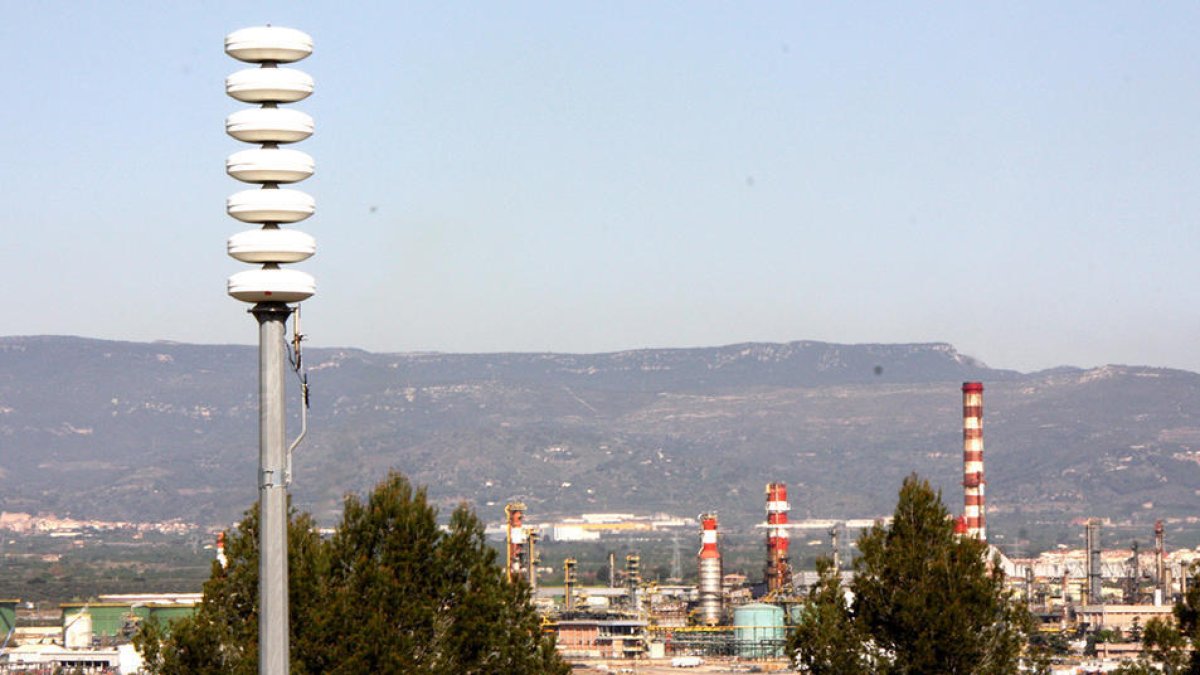 Imatge d'arxiu d'una de les sirenes de risc d'accident químic, amb el polígon petroquímic nord de Tarragona, al fons.