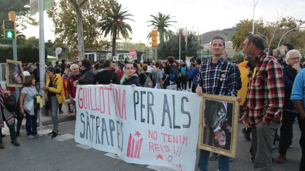 Uns manifestants aguanten una pancarta en contra de la visita del rei Felip VI a Barcelona