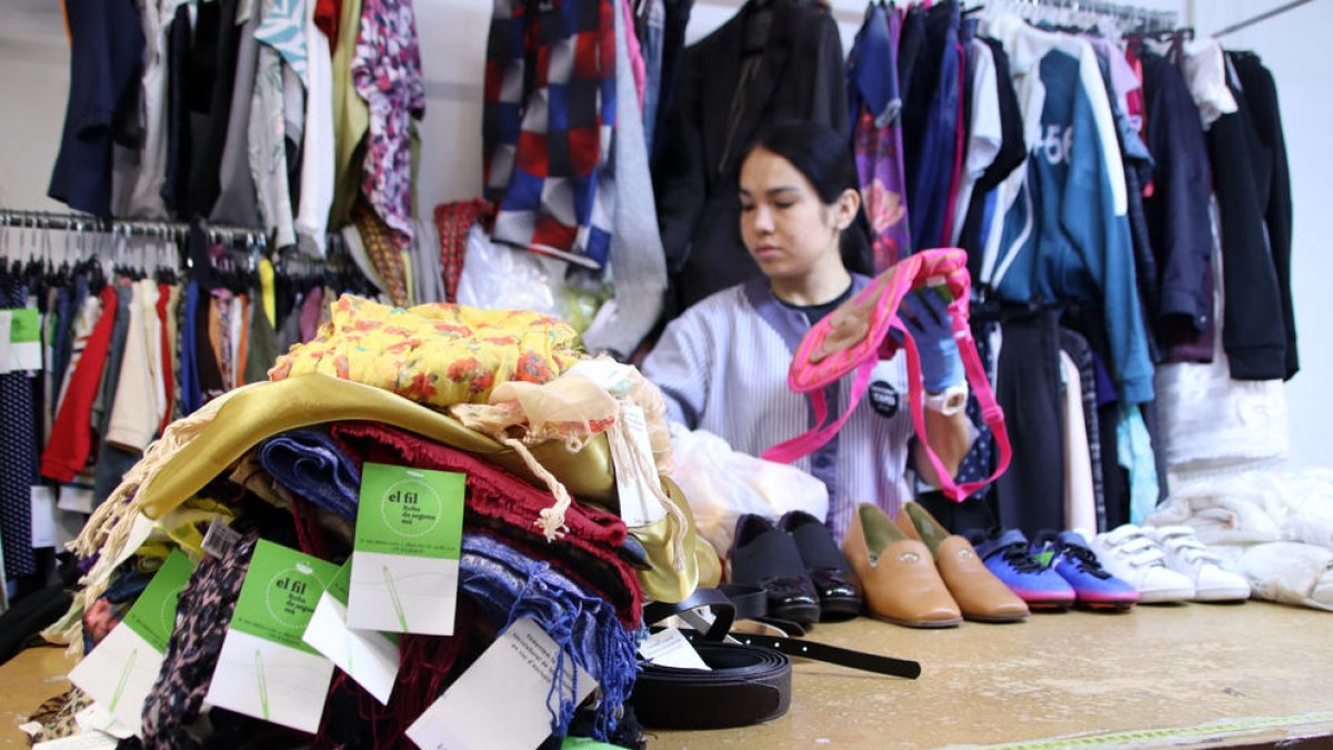 Una treballadora seleccionant la roba que es posarà a la venda a la seva botiga.