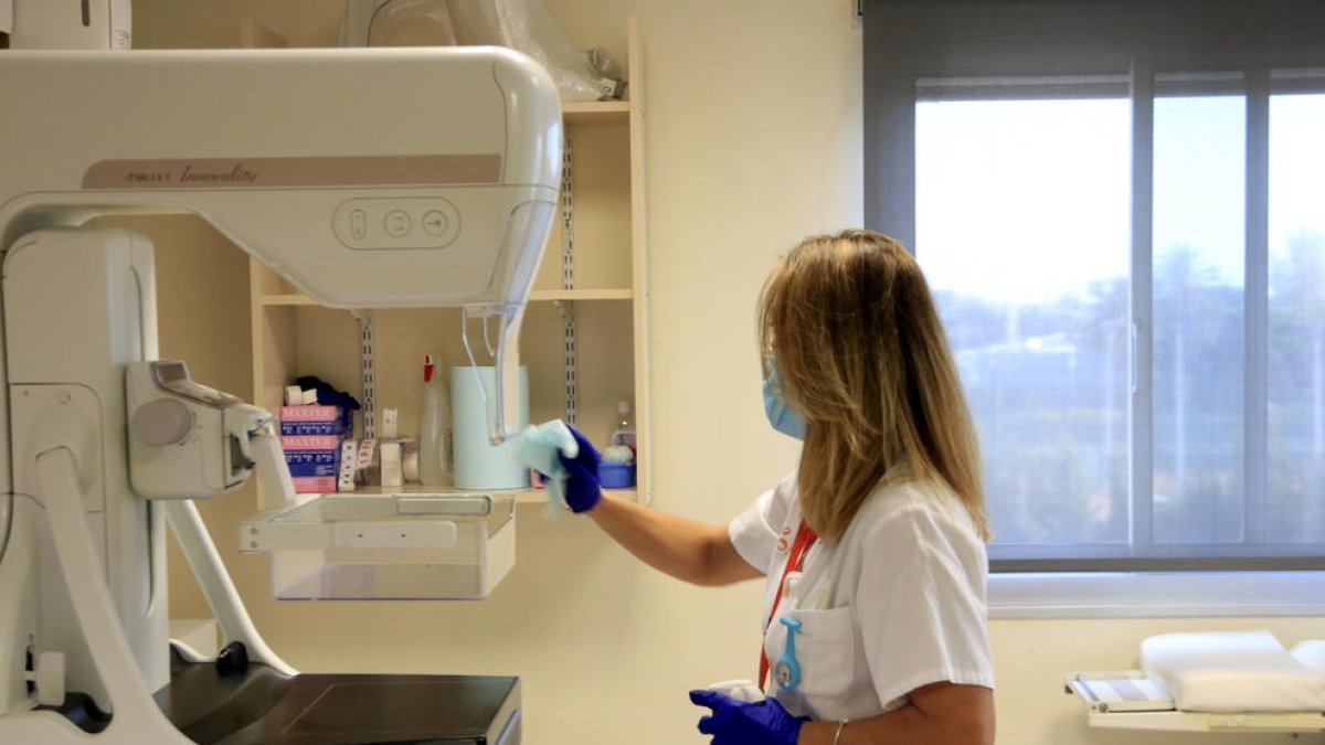 Una sanitaria desinfecta un mamógrafo antes de utilizarlo de nuevo para la criba o programa de detección temprana del cáncer de mama, en el Instituto Catalán de Oncología (ICO).