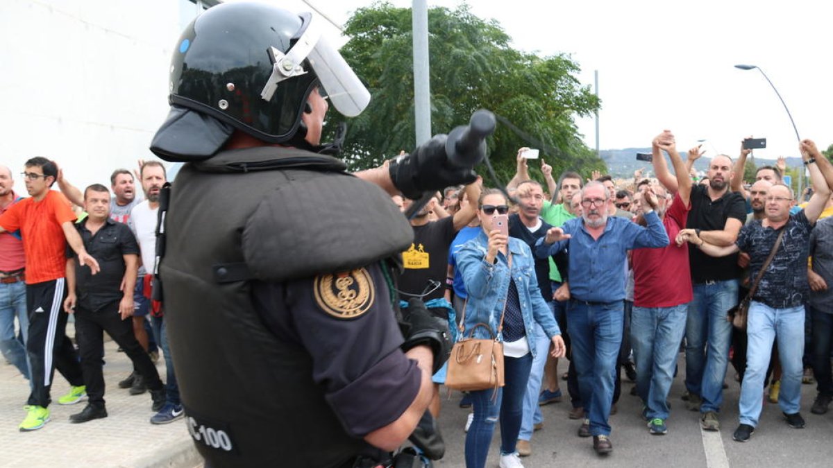 Un agente de la Guardia Civil enseñando la porra a los ciudadanos que les increpaban por su actuación en Roquetes.
