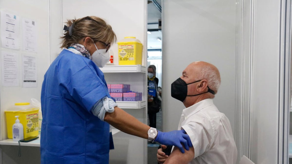 Una enfermera habla con un hombre justo después de que reciba la vacuna en el punto habilitado en Fira de Barcelona.