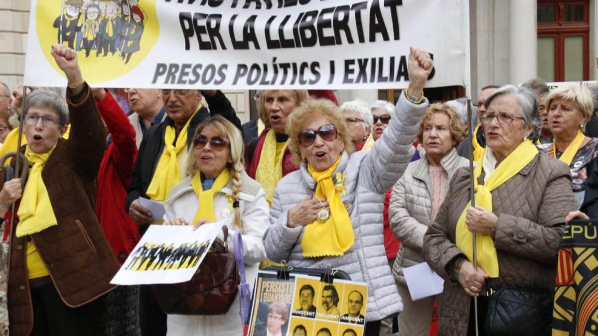 Àvies, amb el puny alçat, cantant Els Segadors, a la plaça del Mercadal de Reus, amb motiu del segon aniversari.