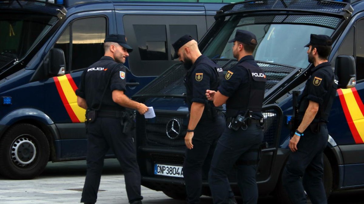Plano medio de varios agentes antidisturbios de la Policía Nacional en el aeropuerto del Prat.