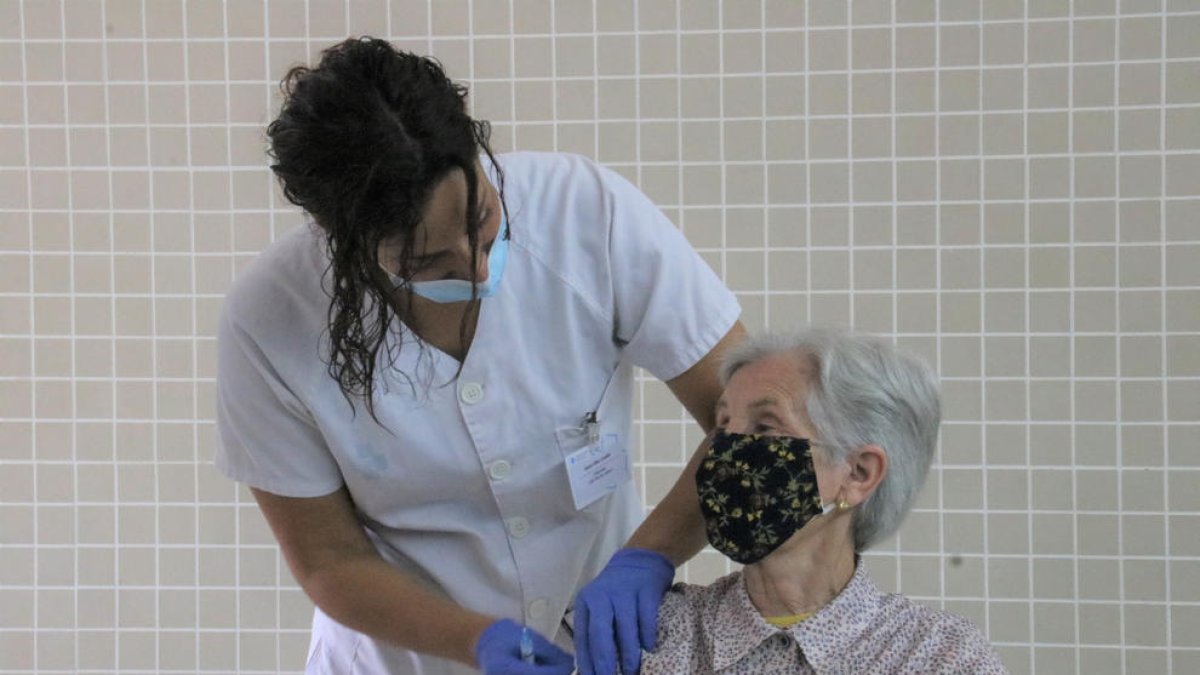 Una infermera administrant la vacuna a una dona al CAP Rio de Janeiro de Barcelona.