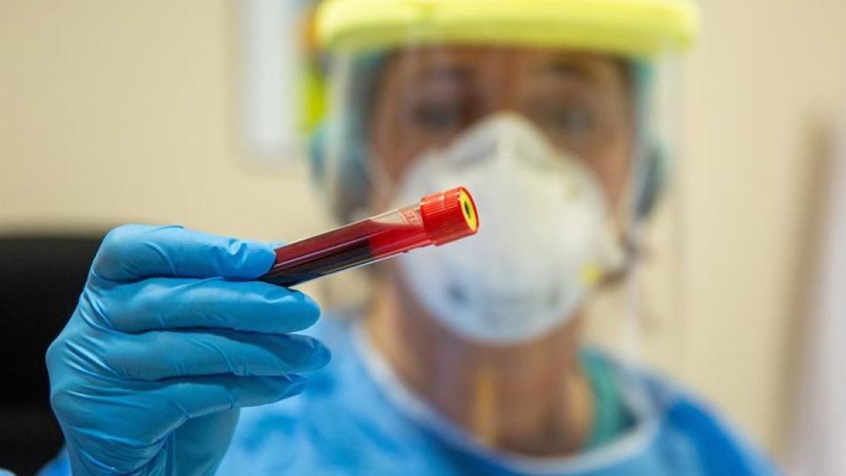 Una sanitària mostra un vial amb sang en un centre de salut.