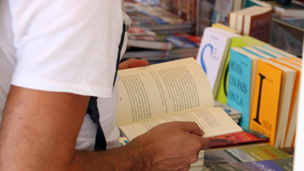 Una persona fulleja un llibre durant la darrera edició de la Setmana del Llibre en Català.