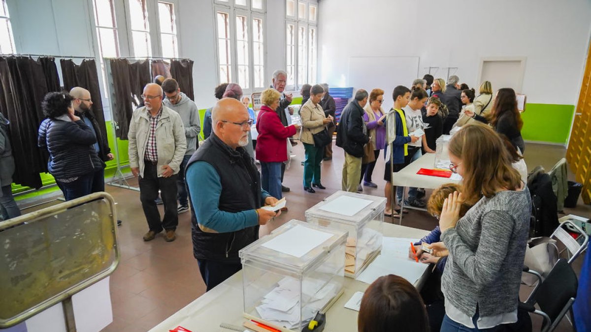 Imagen de las mesas electorales y de algunos votantes en Tarragona.