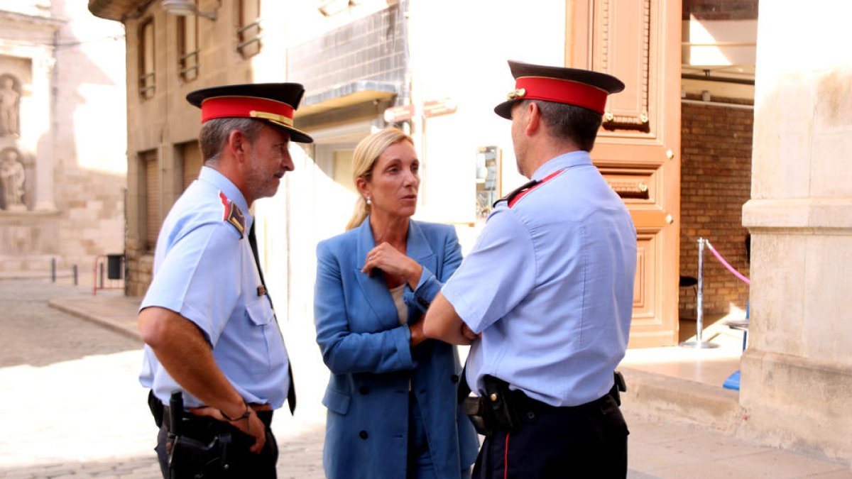 L'alcaldessa de Valls, Dolors Farré, acompanyada de dos agents dels Mossos d'Esquadra davant de l'Ajuntament.