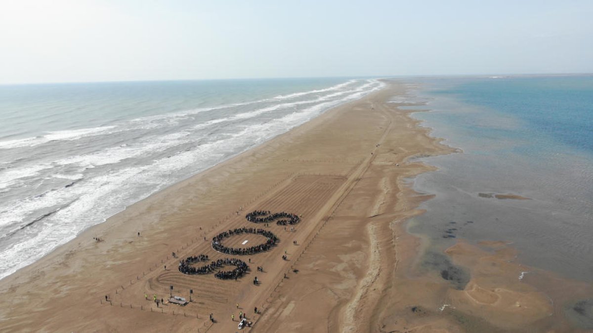 Los asistentes al acto del MOLDE han configurado las letras SOS en la playa del trabucador.