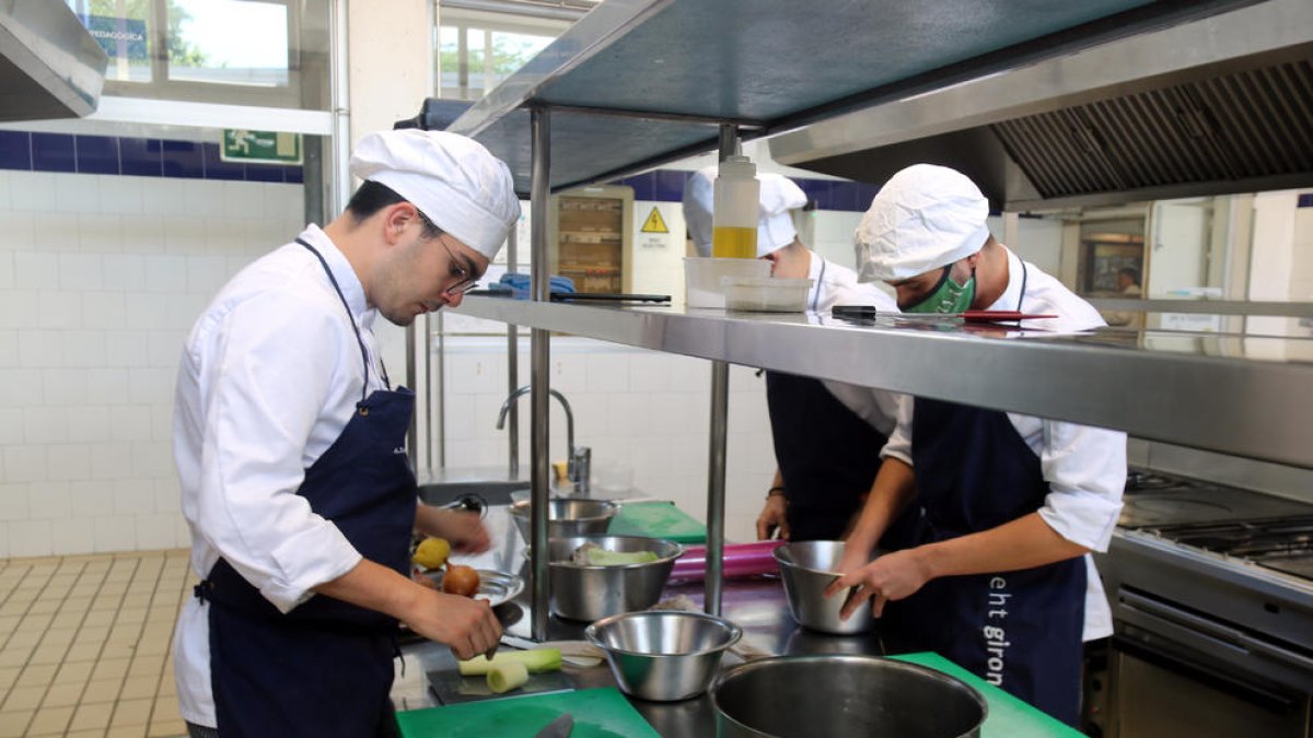 Estudiants de cuina fent pràctiques als fogons.