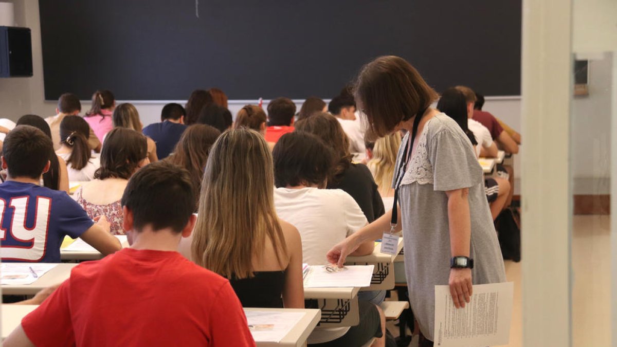 Una membre del tribunal de les PAU comprova les dades d'una estudiant.