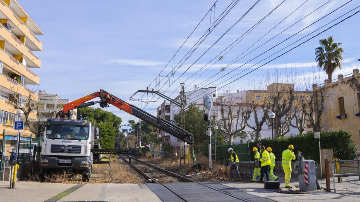 Imatge d'arxiu d'operaris d'Adif retirant el pas a nivell del carrer de Barcelona de Salou.