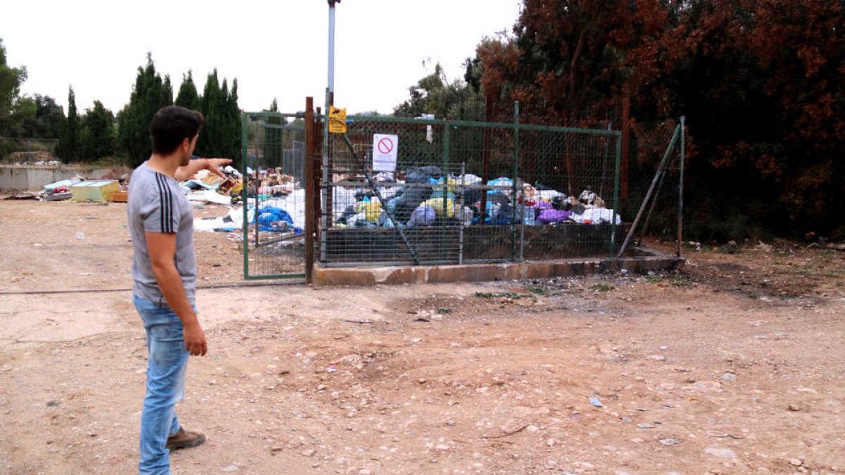 L'alcalde d'Arnes, Joaquim Miralles, assenyala la zona on els llencen bosses de brossa de manera irregular.