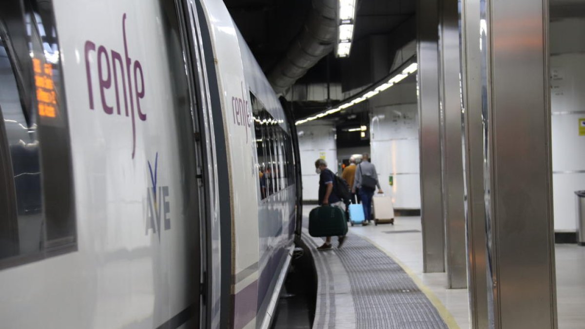 Una persona entrant a un tren AVE a l'estació de Sants de Barcelona.