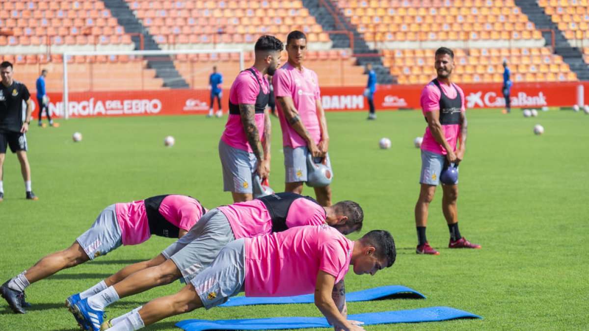 Jugadors del Nàstic, entre ells Andy Escudero, fan exercicis d'estirament en l'entrenament d'ahir.