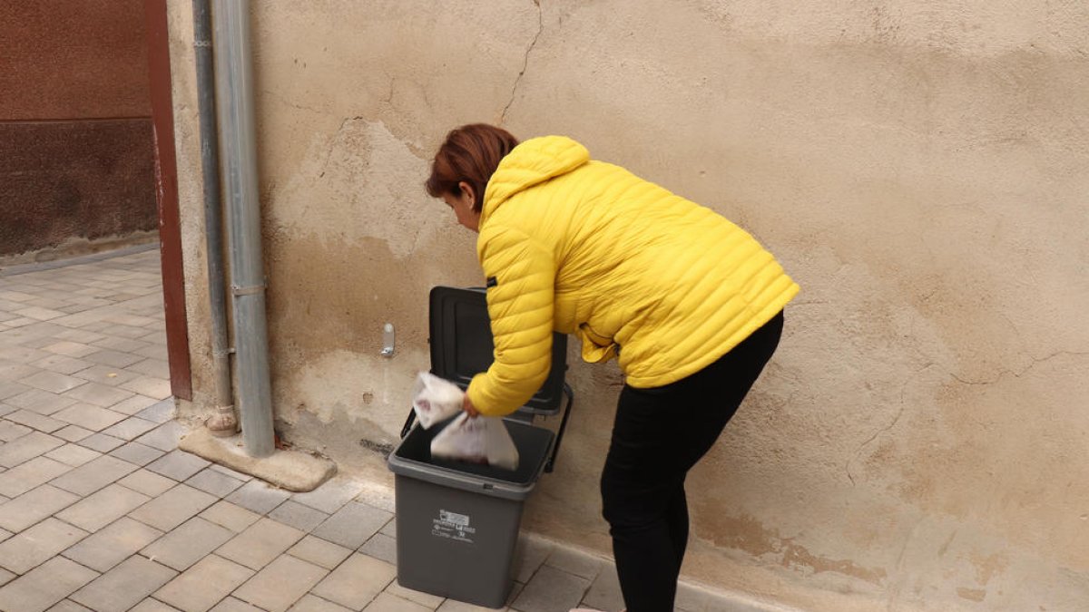 Imatge d'una veïna de Castellvell del Camp llençant la brossa al cubell.